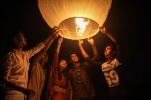 woman and men holding on a paper lantern